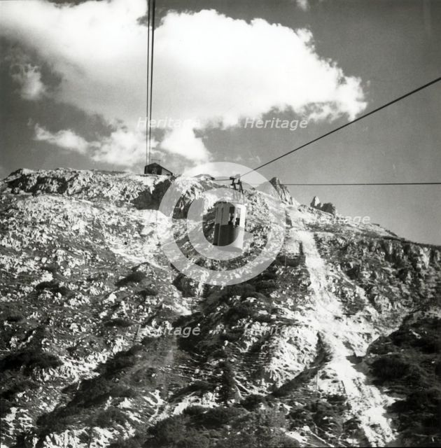 Cable car going up to Tondi di Faloria above Cortina, Dolomites, Italy, c1955.  Creator: Arthur Charles Kirby Ware.