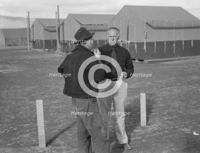 Camp manager talking to another man, FSA mobile camp, Merrill, Klamath County, Oregon, 1939. Creator: Dorothea Lange.