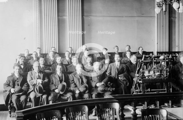 Candidates for naturalization seated in room, hats in laps, 1916. Creator: Bain News Service.