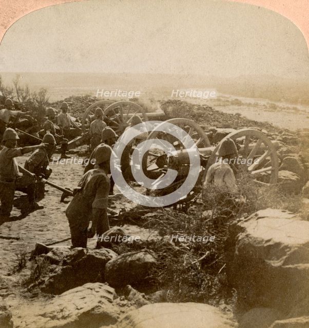 Cape Garrison artillery making it hot for the Boers across the Modder River, South Africa, 1900. Artist: Underwood & Underwood