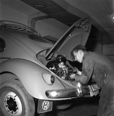 Car mechanic servicing a Volkswagen, Vallingby, Sweden, 1956. Creator: Unknown