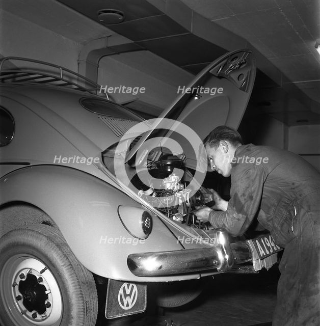 Car mechanic servicing a Volkswagen, Vallingby, Sweden, 1956. Creator: Unknown.