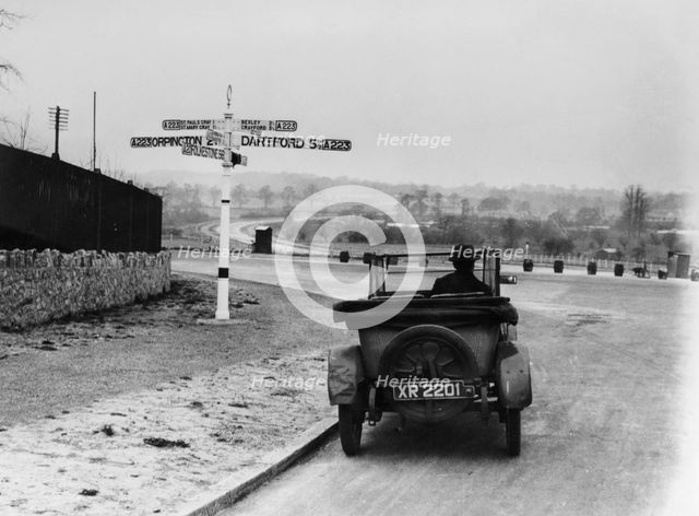 Car near a road sign, Bromley, Kent, 1920s. Artist: Unknown
