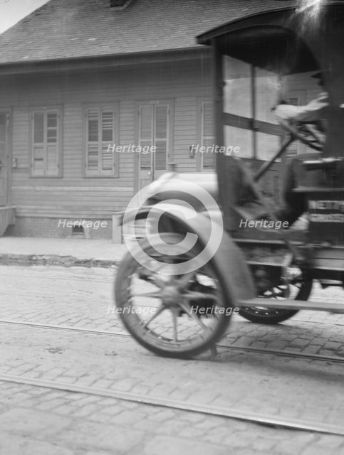 Car driving down a street, New Orleans or Charleston, South Carolina, between 1920 and 1926. Creator: Arnold Genthe.