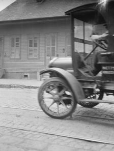 Car driving down a street, New Orleans or Charleston, South Carolina, between 1920 and 1926. Creator: Arnold Genthe