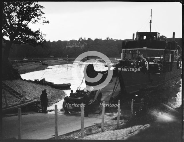 Car driving off the slipway on to the Isle of Wight Ferry at Fishbourne, Isle Of Wight, 1925-35. Creator: George R Long.