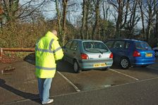 Car Park attendant recording car registration numbers
