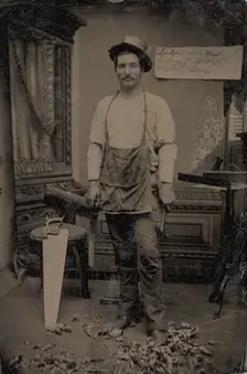 Carpenter or Cabinetmaker Standing Before a Sign Advertising His Trade, 1860s-80s. Creator: Unknown