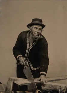 Carpenter Sawing a Plank of Wood, 1880s-90s. Creator: Unknown