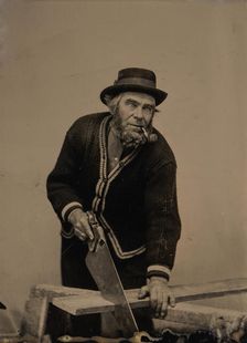 Carpenter Sawing a Plank of Wood, 1880s-90s. Creator: Unknown
