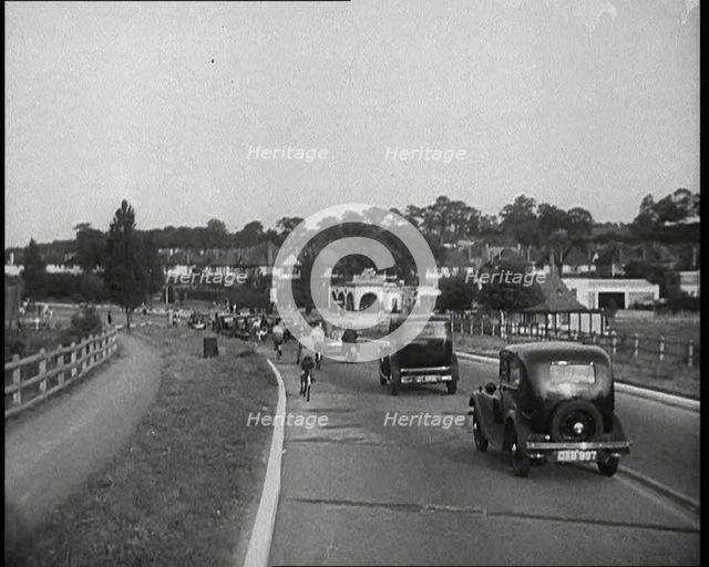 Cars and Bikes Driving Down a Road Away from the Camera, 1930s. Creator: British Pathe Ltd.