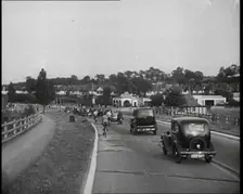 Cars and Bikes Driving Down a Road Away from the Camera, 1930s. Creator: British Pathe Ltd