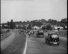 Cars and Bikes Driving Down a Road Away from the Camera, 1930s. Creator: British Pathe Ltd