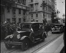 Cars Driving Down a Road, Watched by a Crowd, 1934. Creator: British Pathe Ltd
