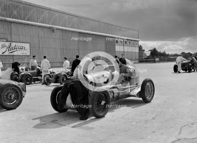Cars of George Harvey-Noble, Charles Goodacre and Bert Hadley, BRDC 500 Mile Race, Brooklands, 1937. Artist: Bill Brunell.