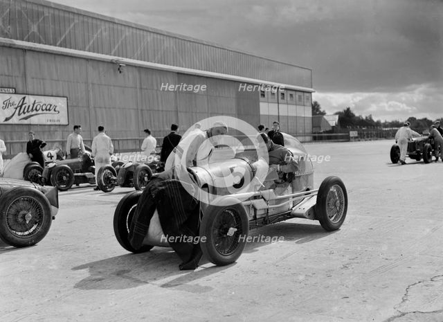 Cars of George Harvey-Noble, Charles Goodacre and Bert Hadley, BRDC 500 Mile Race, Brooklands, 1937. Artist: Bill Brunell.