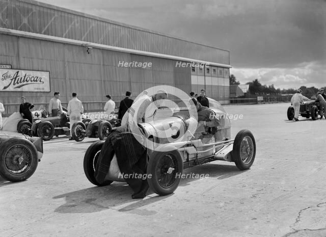Cars of George Harvey-Noble, Charles Goodacre and Bert Hadley, BRDC 500 Mile Race, Brooklands, 1937. Artist: Bill Brunell.