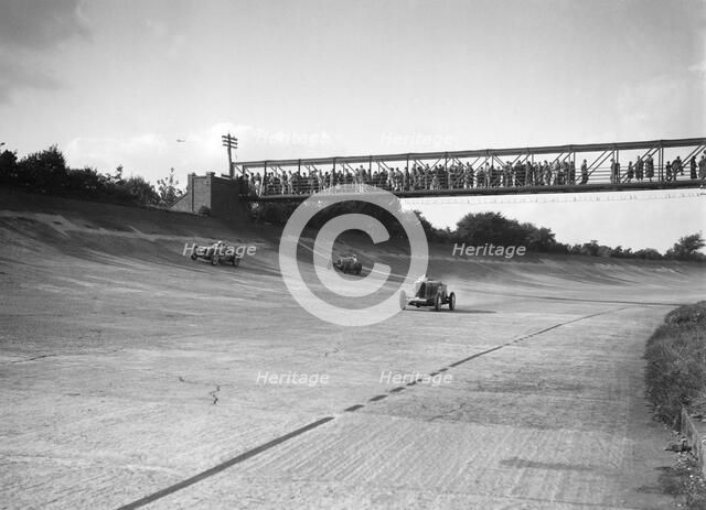 Cars racing on Byfleet Banking during the BRDC 500 Mile Race, Brooklands, 3 October 1931. Artist: Bill Brunell.