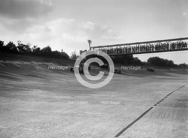 Cars racing on Byfleet Banking during the BRDC 500 Mile Race, Brooklands, 3 October 1931. Artist: Bill Brunell.