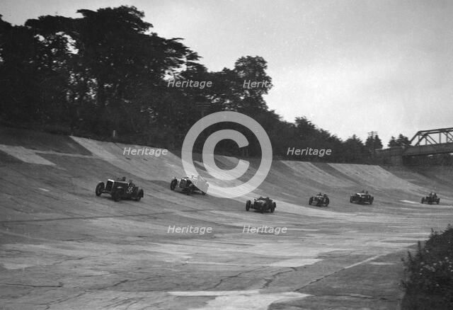 Cars racing on the banking at a JCC Members Day, Brooklands. Artist: Bill Brunell.