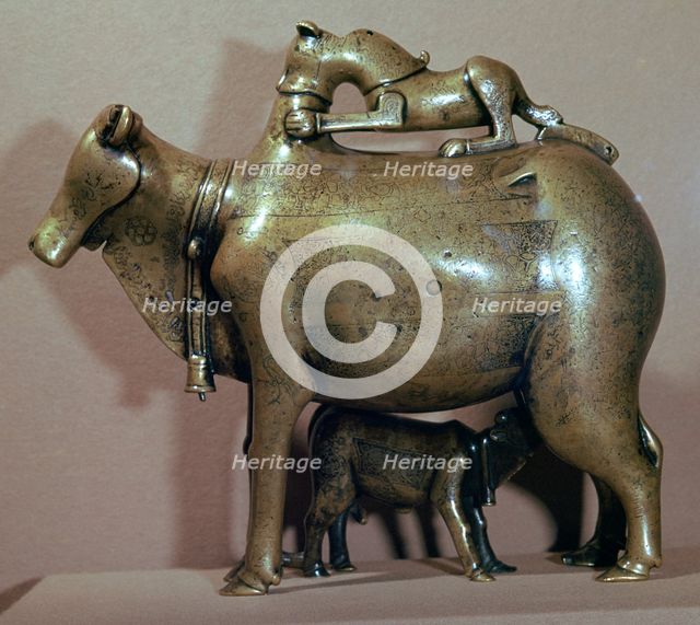Cast bronze zebu-cow suckling her calf while a lion attacks her back, 13th century. Artist: Unknown