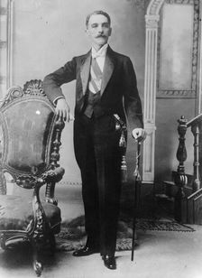 C.E. Restrepo posing next to chair, with cane, 1910. Creator: Bain News Service