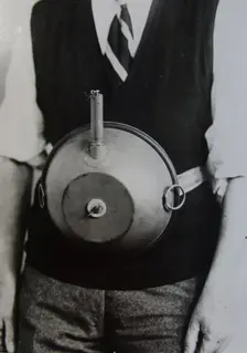 Cecil Vandepeer Clarke wearing an early version of the limpet mine on a keeper plate, c1939. Creator: British Government
