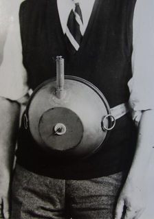 Cecil Vandepeer Clarke wearing an early version of the limpet mine on a keeper plate, c1939. Creator: British Government
