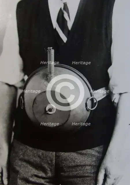 Cecil Vandepeer Clarke wearing an early version of the limpet mine on a keeper plate, c1939.  Creator: British Government.