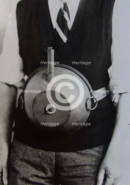 Cecil Vandepeer Clarke wearing an early version of the limpet mine on a keeper plate, c1939.  Creator: British Government.