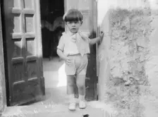 Cenerini, Mr., child of, standing in a doorway, 1929 Creator: Arnold Genthe