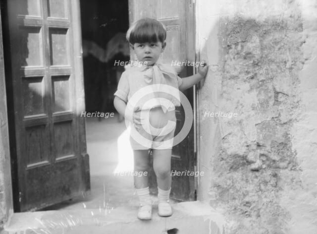 Cenerini, Mr., child of, standing in a doorway, 1929 Creator: Arnold Genthe.