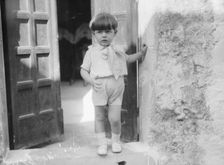 Cenerini, Mr., child of, standing in a doorway, 1929 Creator: Arnold Genthe