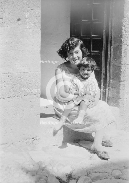 Cenerini, Mrs., and child, seated on a doorstep, 1929 Creator: Arnold Genthe.