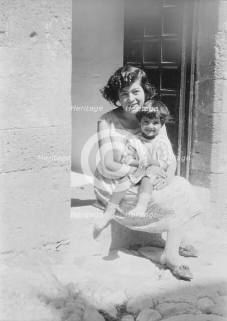 Cenerini, Mrs., and child, seated on a doorstep, 1929 Creator: Arnold Genthe.