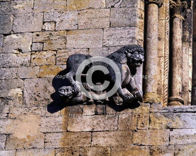Church of San Pedro de Besalu, lion protecting a human figure and decorating the front window of …