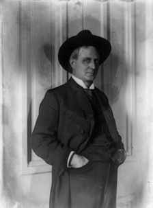 Champ Clark, half-length portrait, standing, facing right, hands in pants pockets, (1898?). Creator: Frances Benjamin Johnston