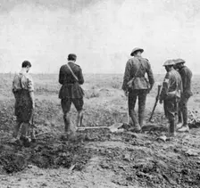 Chaplain conducting burial service in the field while burial party pay their respects, c1916