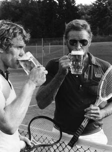 Charlton Heston and Sepp Maier have a beer after playing tennis, Munich, Germany, 1976