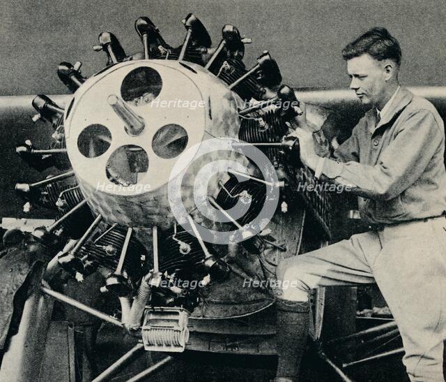 Charles Lindbergh checking the engine of his aircraft before his transatlantic flight, 1927 (c1937). Artist: Unknown.