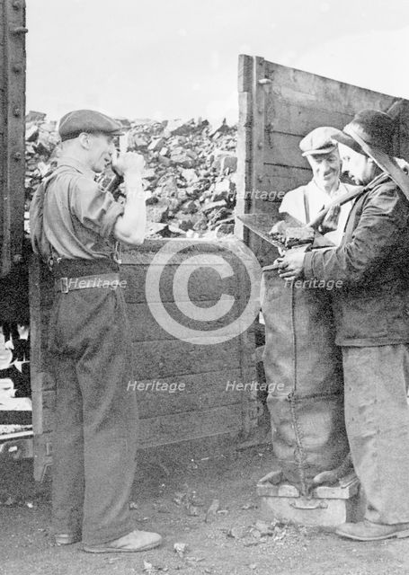 Charringtons' workers filling sacks of coal. Creator: Unknown.
