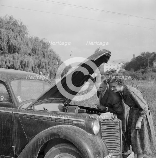 Checking the engine under the bonnet of an Opel Olympia, Landskrona, Sweden, 1959. Creator: Unknown.