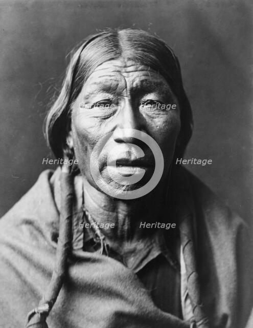 Cheyenne male, facing front, hair in wrapped braids, blanket around shoulders, c1910. Creator: Edward Sheriff Curtis.