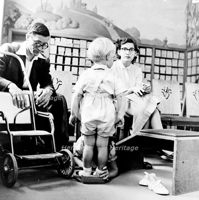 Child being fitted for new shoes in a London shoe shop, c1950s. Creator: Henry Grant.