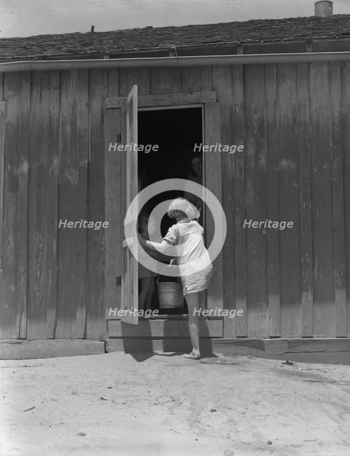 Child of Texas sharecropper carrying water, 1937. Creator: Dorothea Lange.