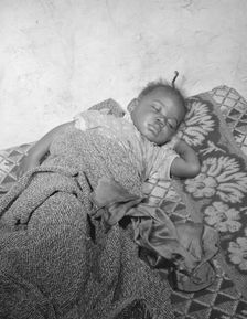 Child seriously ill from an infection caused by a rat bite in her home..., Washington, D.C., 1942. Creator: Gordon Parks