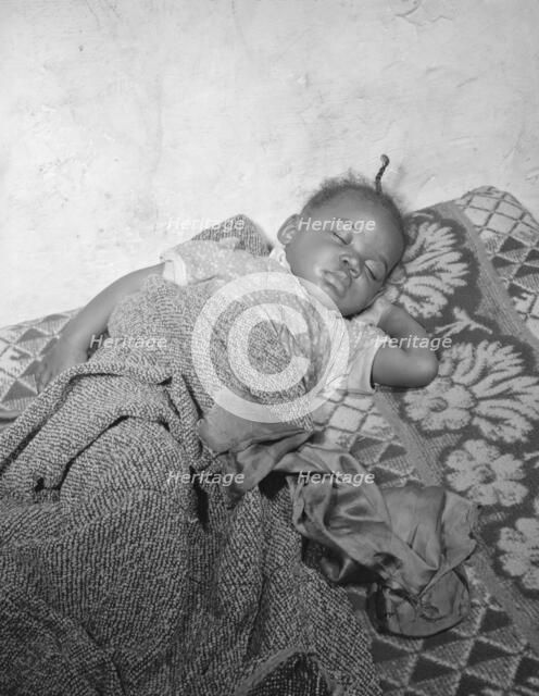 Child seriously ill from an infection caused by a rat bite in her home..., Washington, D.C., 1942. Creator: Gordon Parks.