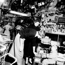 Child trying out a toy in a London toy store, c1950s. Creator: Henry Grant