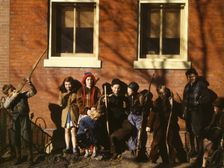 Children aiming sticks as guns, lined up against a brick building, Washington, D.C.?, 1941-1942. Creator: Unknown