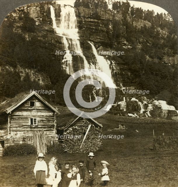 'Children at play in a farmer's field with terraced Tvinde waterfall, Vossevangen, Norway', c1905. Creator: Unknown.